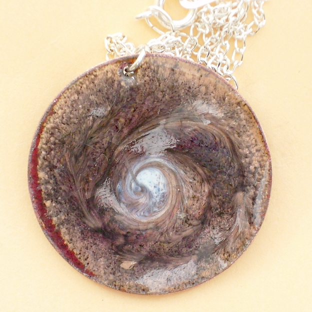 white, black, golden-brown scrolled pendant