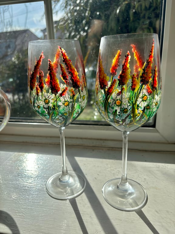 A pair of hand painted and fired wine glasses by Andrew Jenkins