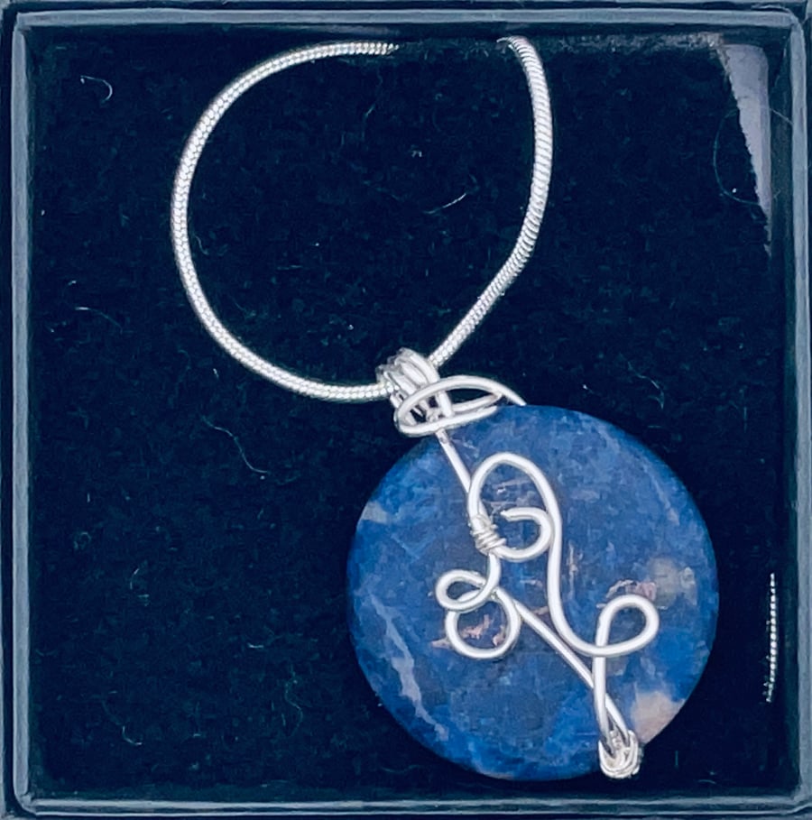 Charming matte circular sodalite  pendant with wire embellishment