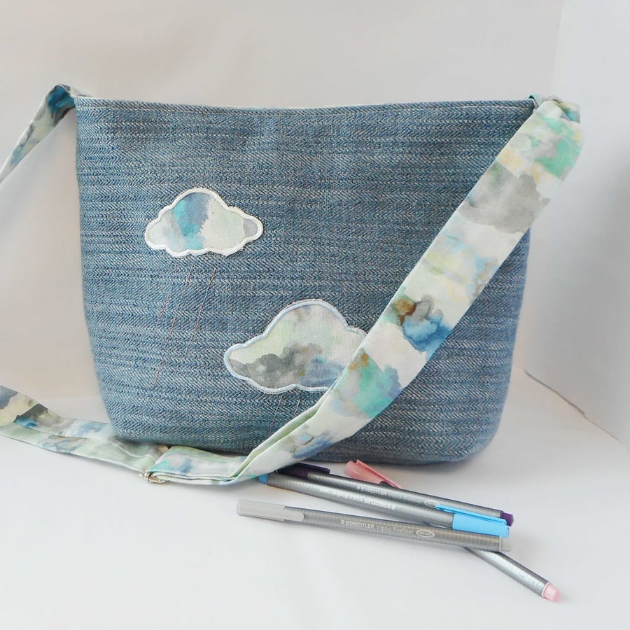 Blue fabric shoulder bag with applique clouds in watercolour print