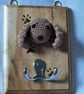 Crocheted spaniel head on wooden board with hooks