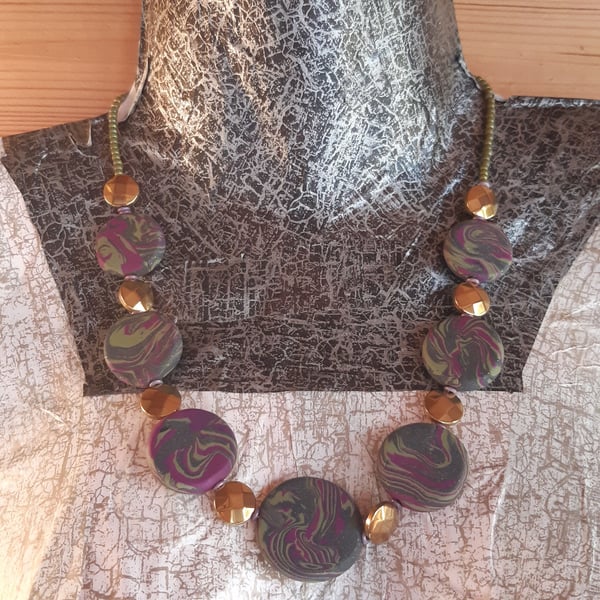 Disc shaped necklace in dark green and magenta