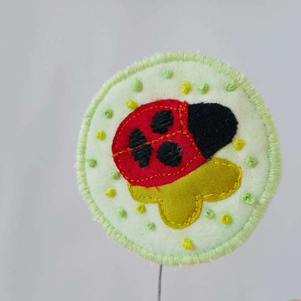 Embroidered Ladybird fabric ornament on wooden block
