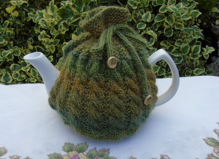 Large tea cosy cable design in green tones, hand knitted in wool 