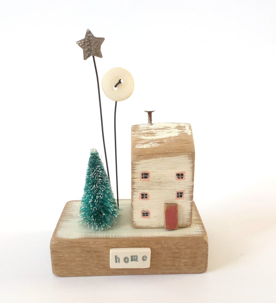 Little wooden house with Christmas tree, star and button