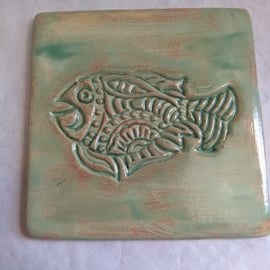 POTTERY COASTER, TURQUOISE GREEN WITH FISH DESIGN  10 CMS X 10 CMS