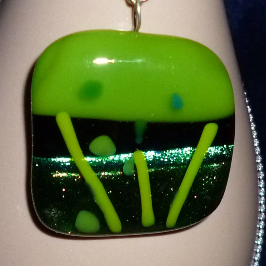 Individual fused glass pendant with dichroic accent, in green tones