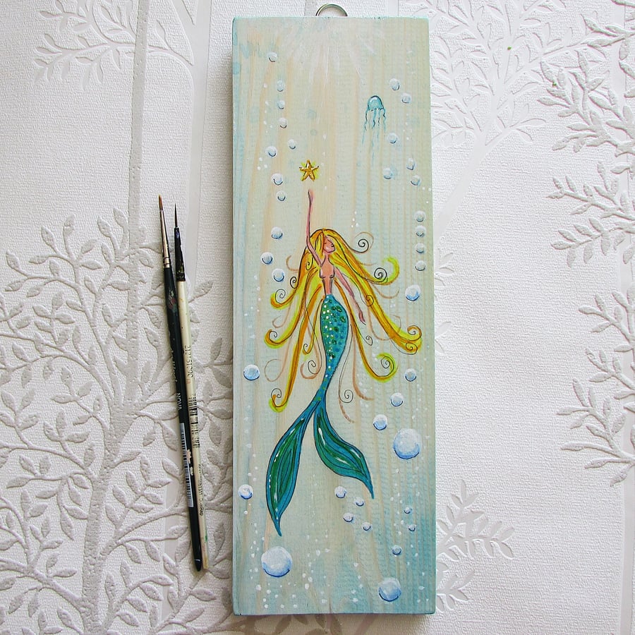 Mermaid swimming painted on wood
