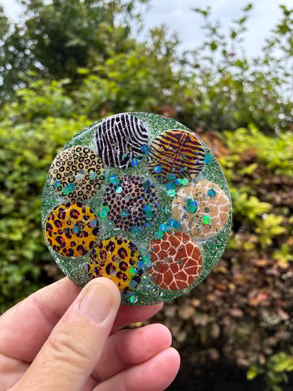 Resin coaster containing safari themed buttons and sprinkled with glitter