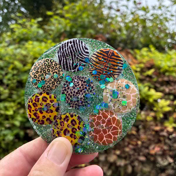 Resin coaster containing safari themed buttons and sprinkled with glitter