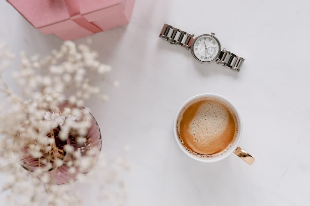 A cup of coffee and flowers on a white table