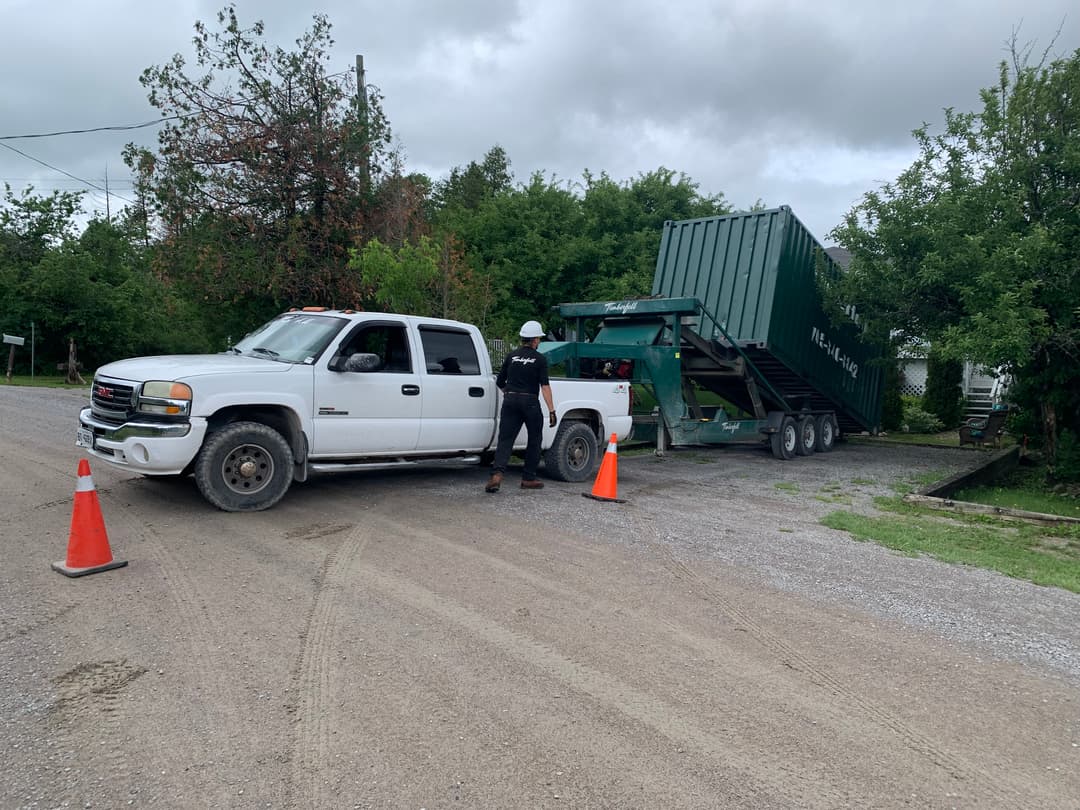 Timberfell delivery truck and tilt trailer dropping off a shipping container in Kawartha Lakes