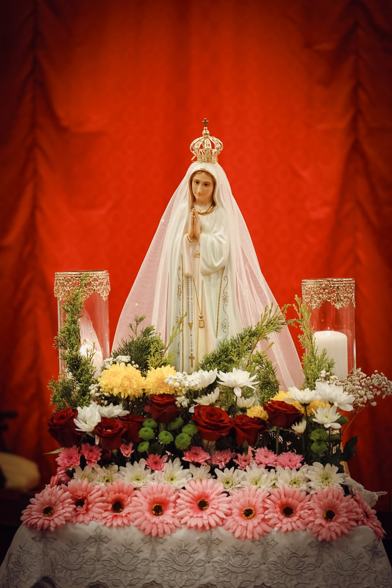 Women praying before a statue of Our Lady
