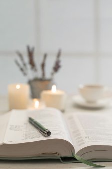 An open Bible beside candles