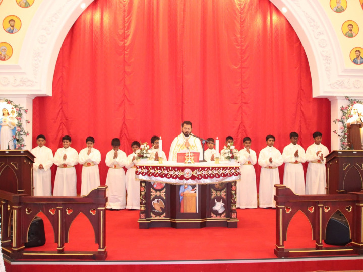 Altar servers standing with the priest at the altar