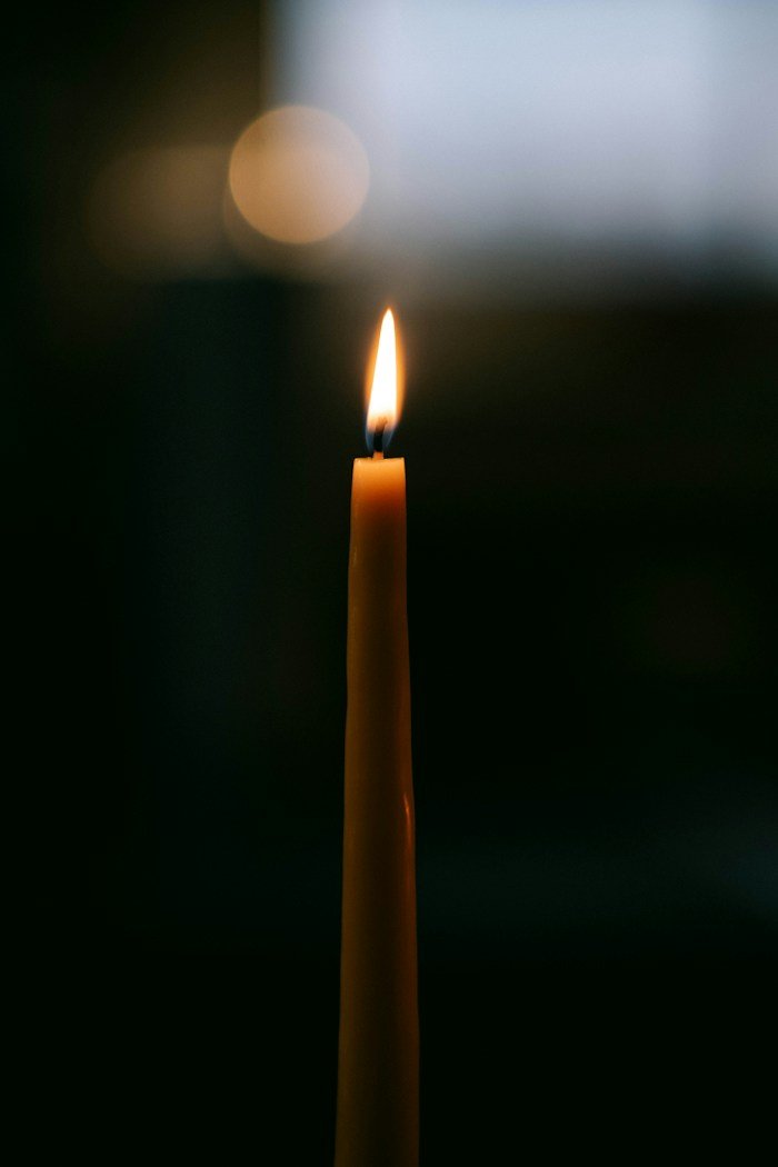 A single candle burning in the dark