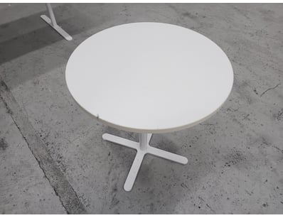 White round pedestal table featuring a clean, mini...