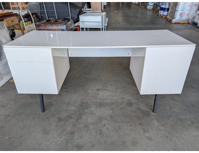 Modern white office desk featuring a spacious work...