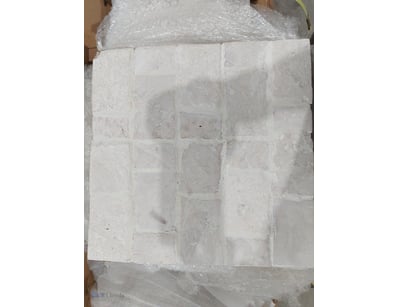 Lot of white marble or limestone tiles arranged in...