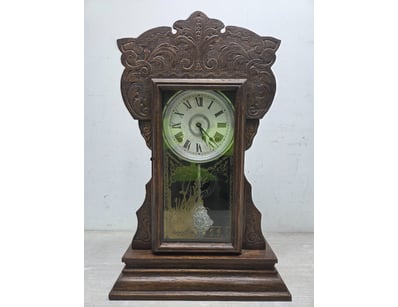 Vintage shelf clock featuring ornate carved wooden...