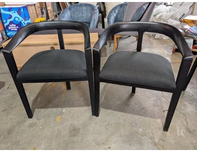 Pair of black armchairs featuring curved, sculptur...
