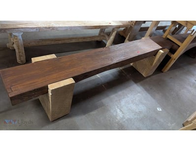 Rustic timber bench featuring a long dark hardwood...
