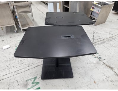 Black pedestal dining table featuring a curved rec...