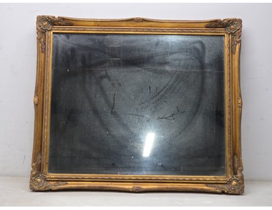 Ornate gilt-framed mirror 
Dimensions 65cm L x 55c...