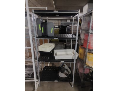 Industrial shelving unit featuring four tiers with...