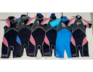 Lot of six children's wetsuits in various styles. ...
