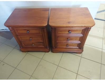 Timber bedside tables, three drawers in each.

Dim...