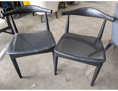 Pair of modern black dining chairs featuring curve...