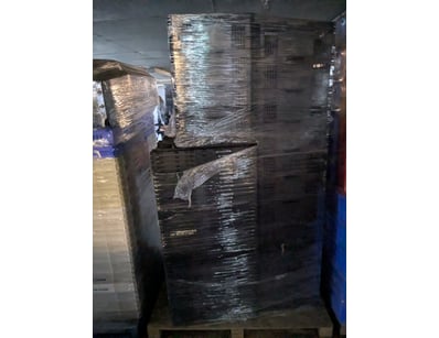 Pallet-mounted stack of black plastic storage crat...