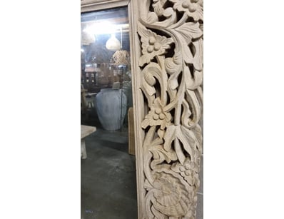 Ornate carved wooden mirror featuring an elaborate...