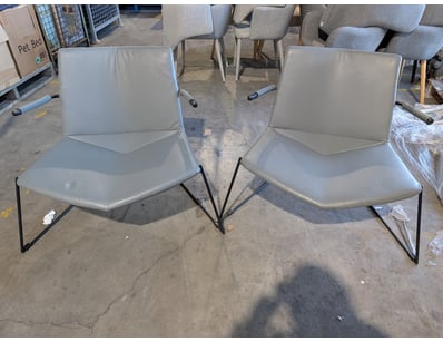 Pair of lounge chairs featuring grey seats and bac...