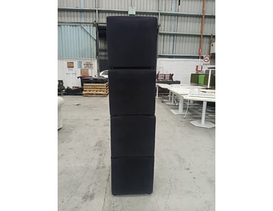 Stack of four black upholstered cubic ottoman/pouf...