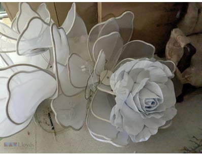 Decorative white fabric flower installation compri...