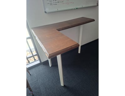 L-shaped desk featuring a two-tone wood constructi...