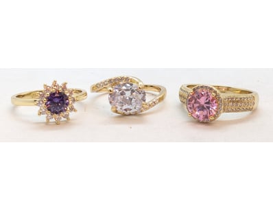 THREE FAUX GOLD RINGS WITH COLOURED GLASS STONE

C...
