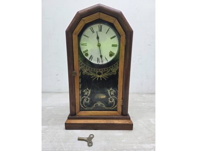 Vintage mantel clock featuring a distinctive woode...