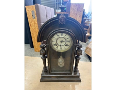 Elegant mantel clock featuring a dark patinated me...