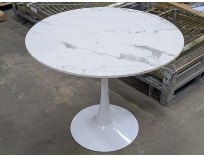 Modern pedestal dining table featuring a white mar...