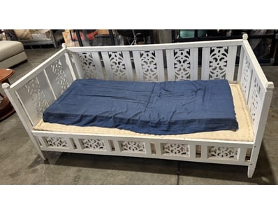 White ornamental wooden cot featuring decorative p...
