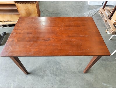 Vintage wooden dining table featuring a rich, warm...