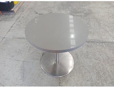 Modern pedestal dining table featuring a sleek sta...