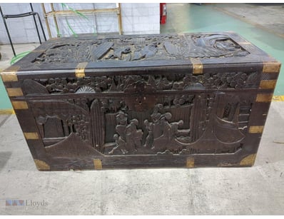 Antique carved wooden trunk featuring elaborate re...