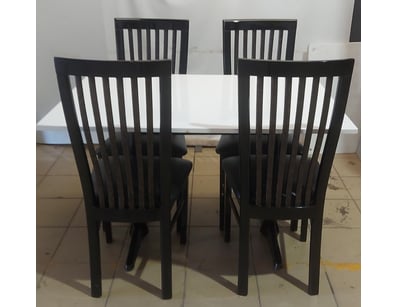 dining table featuring a white table with black wo...