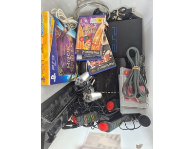 Retro PlayStation 2 gaming bundle featuring a blac...
