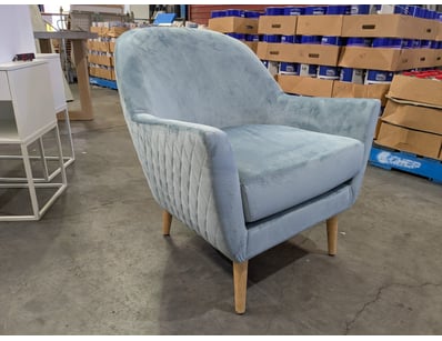 Modern upholstered armchair featuring a light blue...