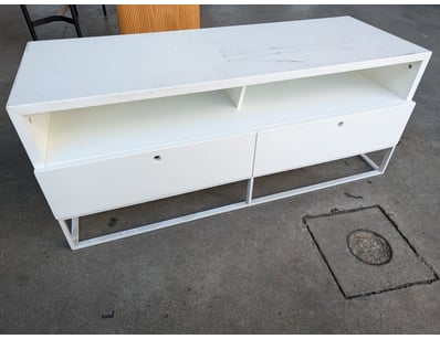 White entertainment unit featuring a minimalist de...